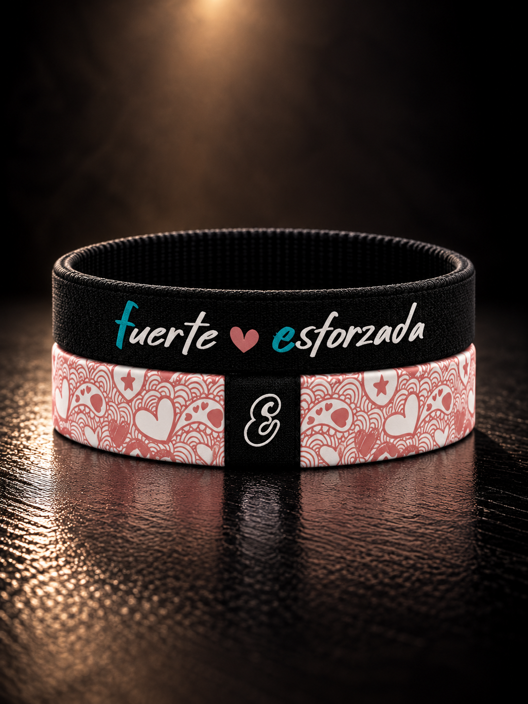 Pulsera cristiana elástica de tela Fuerte y Esforzada de ESCRITOESTÁ sobre fondo oscuro.