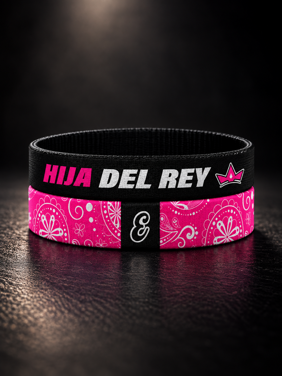 Pulsera cristiana elástica de tela Hija del Rey de ESCRITOESTÁ sobre fondo oscuro.