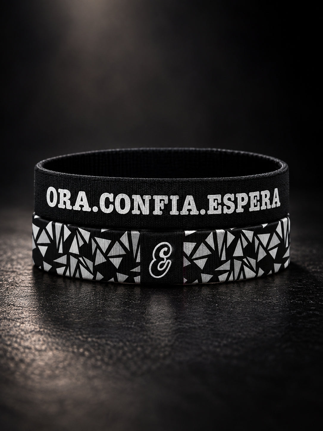 Pulsera cristiana elástica de tela Ora. Confía. Espera. de ESCRITOESTÁ sobre fondo oscuro.